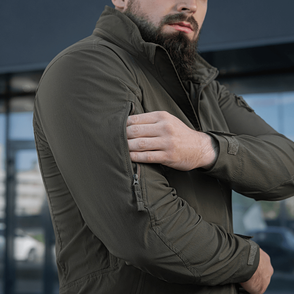 Mand iført M-Tac Flash Jakke viser jakkeenkelhed uden velcro på ærmerne, ideel til sport og hverdagsbrug.