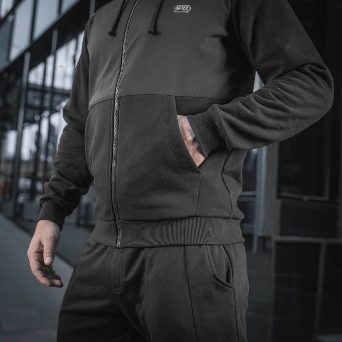 M-Tac Pilgrim Bomberjakke til mænd, stilfuld jakke perfekt til sport og hverdag, med central lynlås og rummelige lommer, set udendørs.