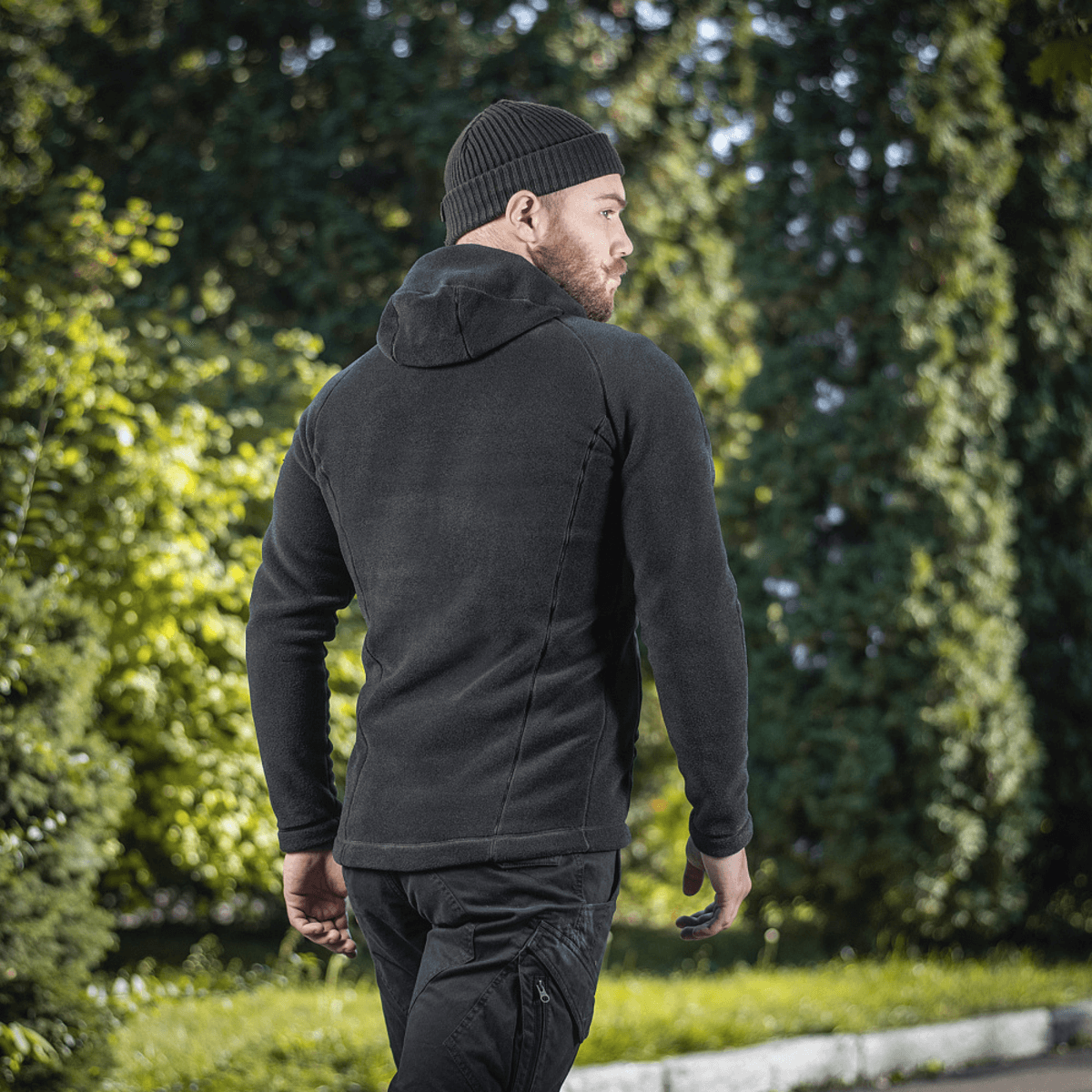 Mand iført M-Tac Sprint Fleece Sweatshirt Polartec med hætte, set bagfra, udendørs omgivelser.