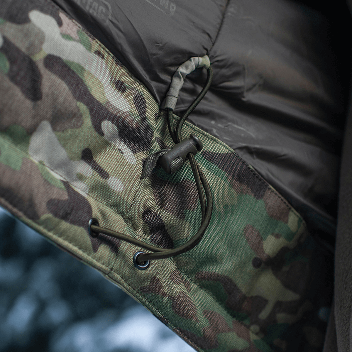 Detalje af M-Tac Alpha Gen.IV Pro Primaloft Vinterjakke i Multicam stof, viser snøring i premium vandafvisende materiale.