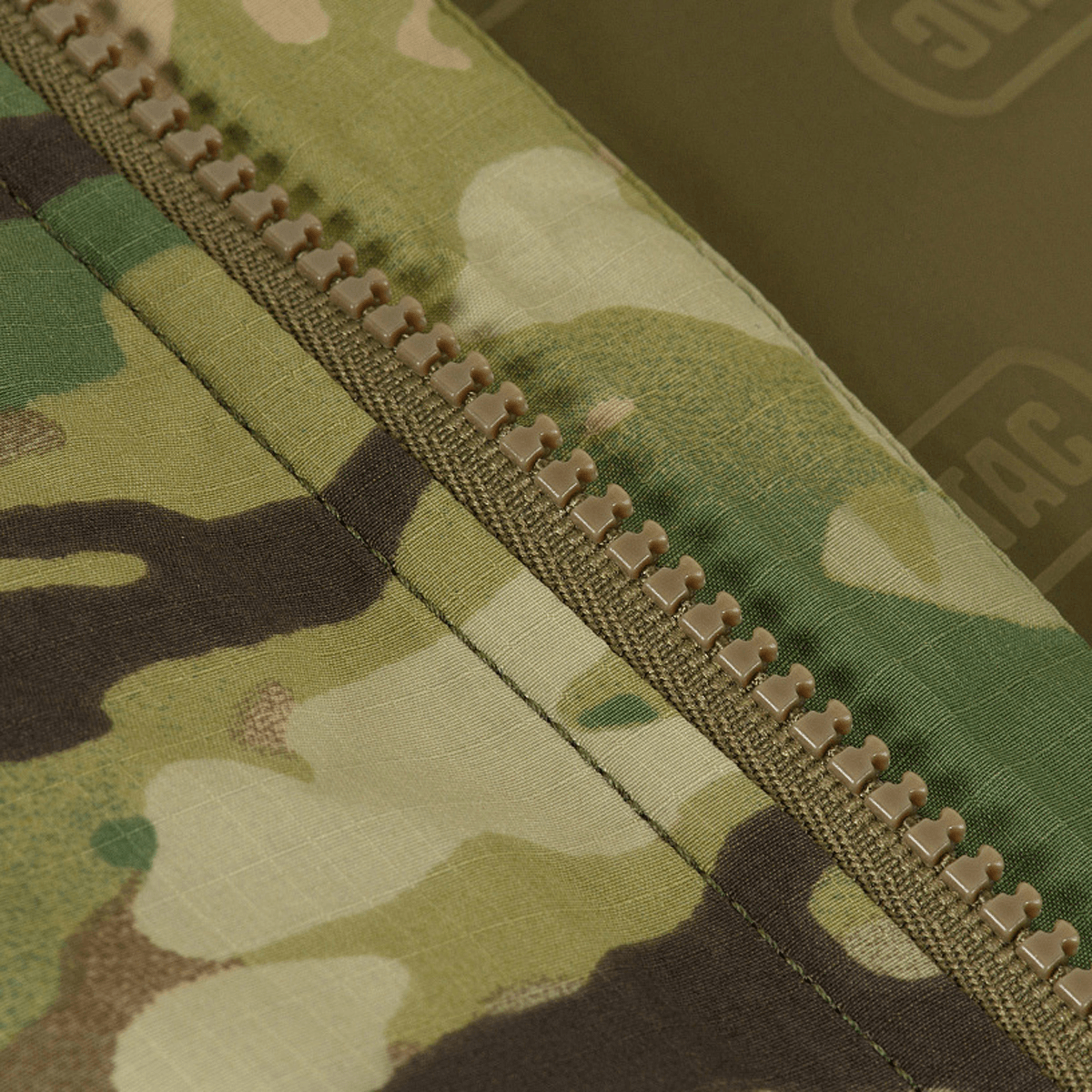 Detaljer af M-Tac Alpha Gen.IV Pro Primaloft Vinterjakke med Multicam mønster og robust lynlås design. Ideel til ekstreme kuldeforhold.