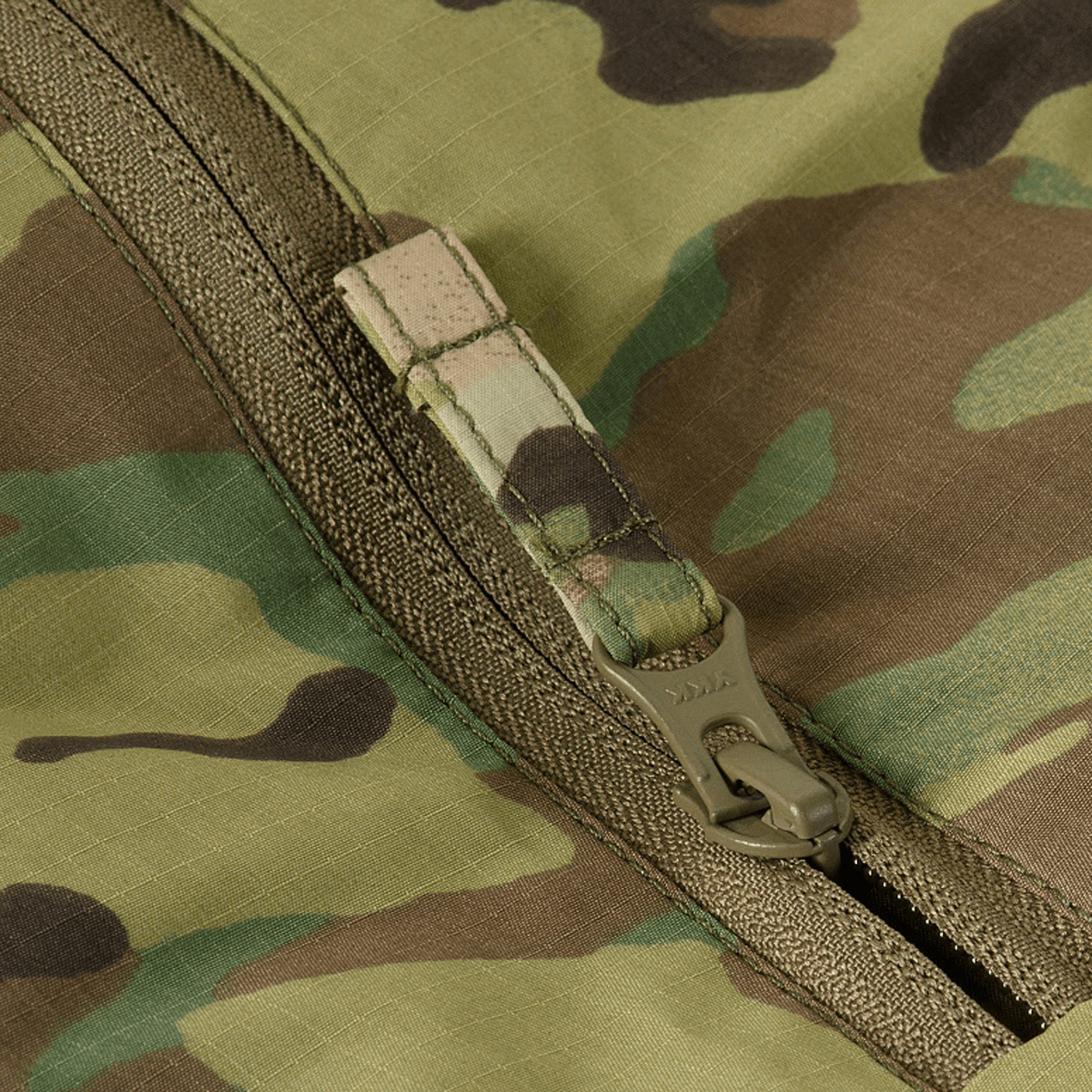 Detalje af lynlås på M-Tac Alpha Gen.IV Pro Primaloft Vinterjakke i Multicam design, fremstillet af slidstærkt vandafvisende stof.