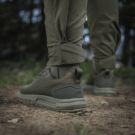 M-Tac Bukser Aggressor Summer Flex Dame i skovmiljø, viser detaljer af bukseben og sko.