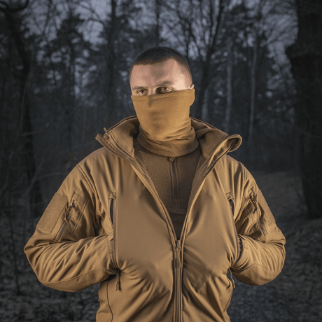 Mand iført M-Tac Tube Scarf Polartec i skov, beskytter mod vind og kulde, ideel til outdoor aktiviteter i kolde årstider.