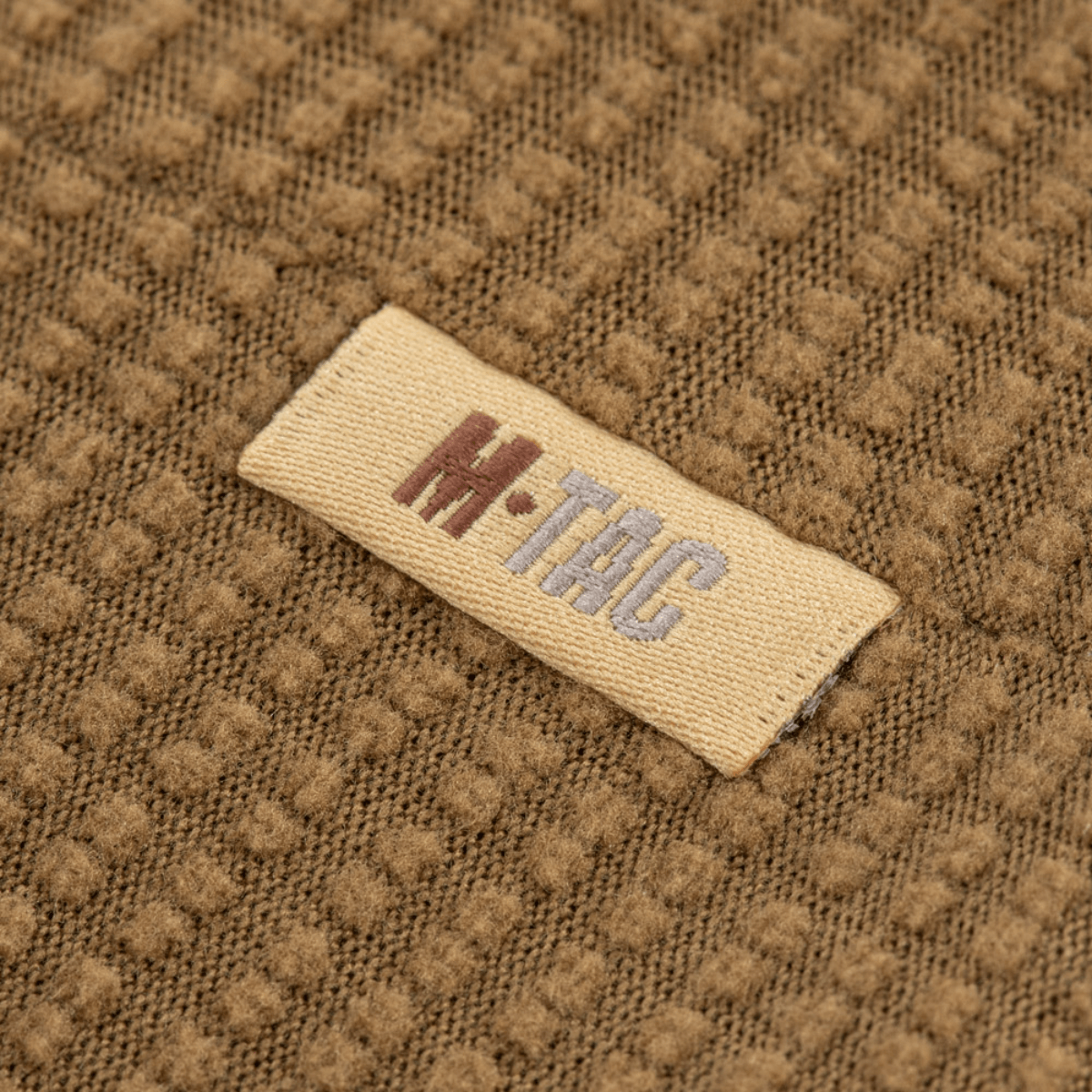 Nærbillede af M-Tac Hjelm Watch Cap Polartec med logo, lavet af slidstærkt Polartec fleece, velegnet til køligt vejr med anti-pilling egenskaber.