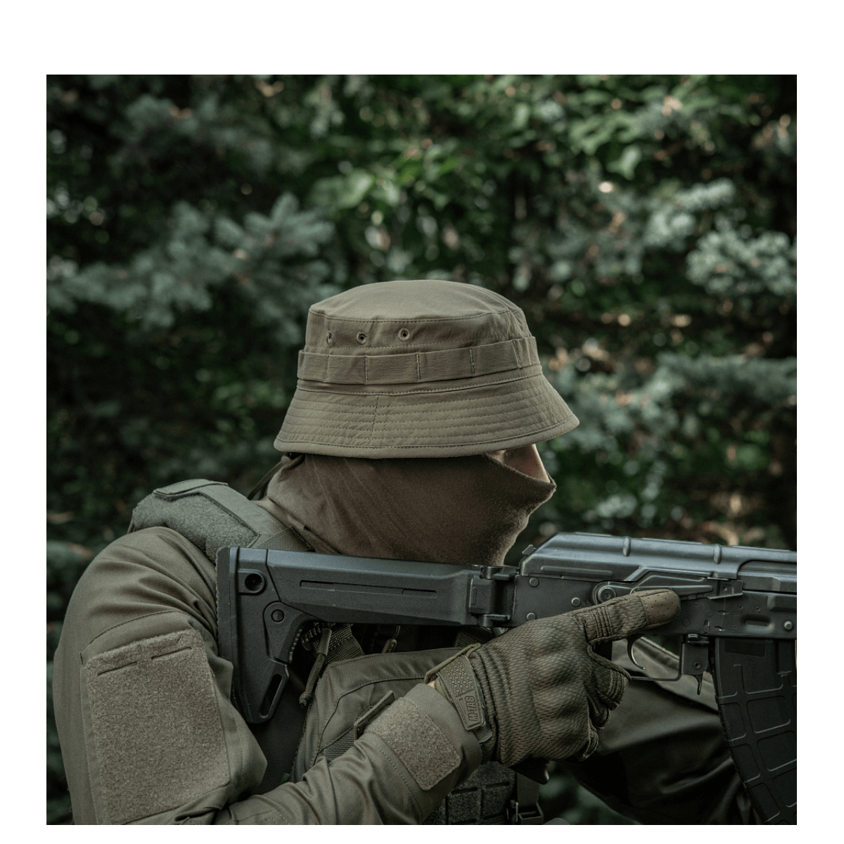 Mand iført M-Tac Panamahat Gen. II Summer Flex camoufleret i skov, ideel til sommervarme og solbeskyttelse