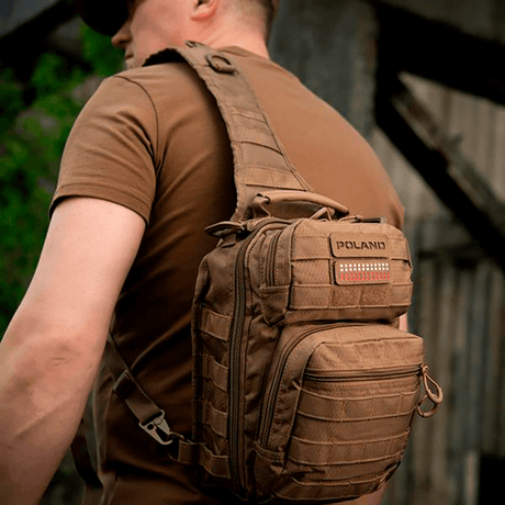Mann med ryggsekk utstyrt med M‑Tac Patch Poland End-to-End 25x80 i holdbart Cordura-materiale, festet med velcro.