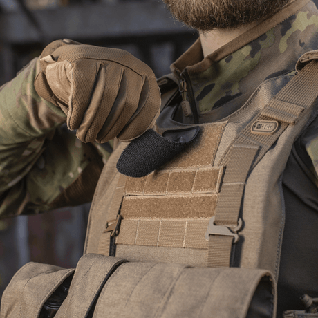 Soldat med M-Tac Spartan Hjelm Patch på vest, viser tapperhet og styrke, laget av Cordura 500D for holdbarhet, 70x80 mm med velcro.