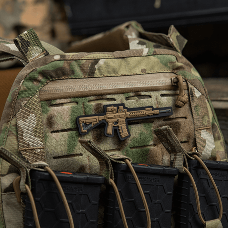 M-Tac AR-15 3D PVC-patch festet på camouflage-ryggsekk med Velcro, taktisk utstyr for AR-15-entusiaster, slitesterkt PVC-materiale.