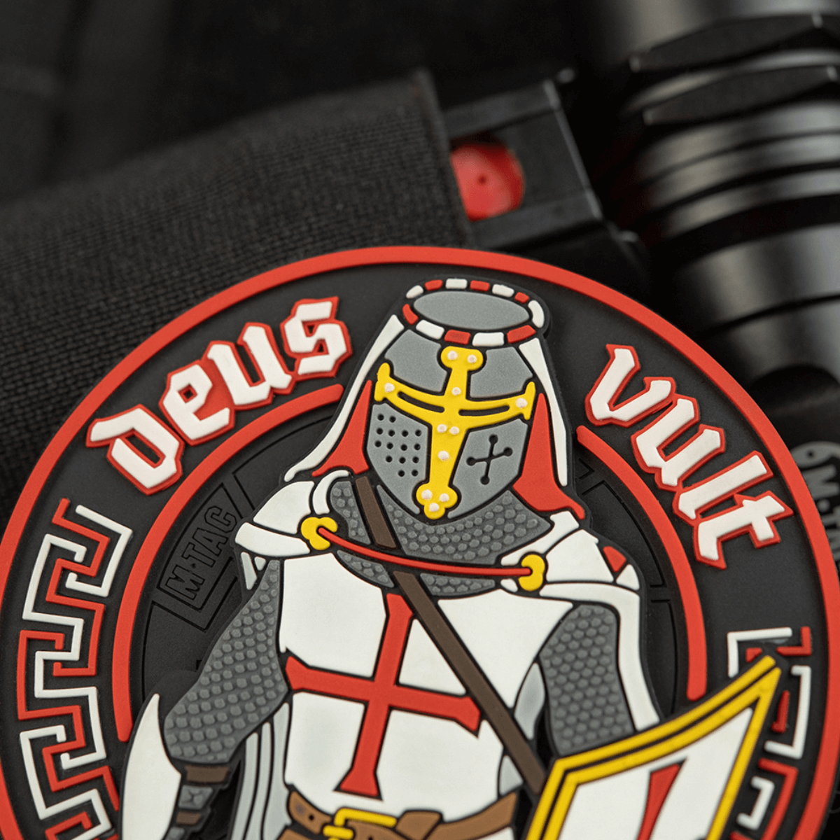 M-Tac Deus Vult 3D PVC Patch i 3D-design med riddermotiv og teksten 'Deus Vult', fastgjort med Velcro på taktisk udstyr. Diameter: 80 mm.