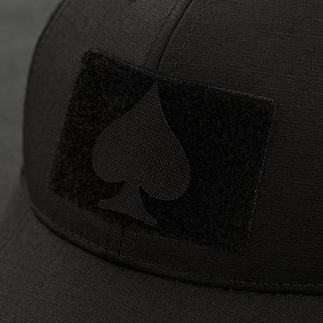 M-Tac Patch Spades Laser Cut festet på svart caps. Taktisk patch med laserutskåret 'Ace of Spades'-symbol. Perfekt for militærbruk