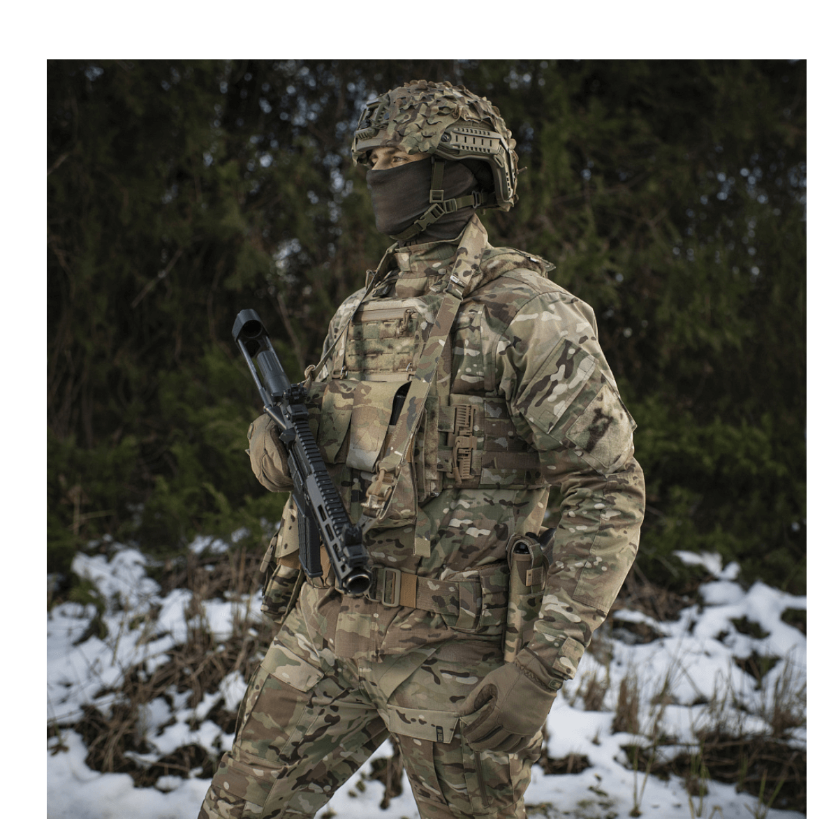 Soldat i camouflageuniform bærer M-Tac Universal Våbenrem med to-punkts fastgørelsessystem, stående i snedækket landskab
