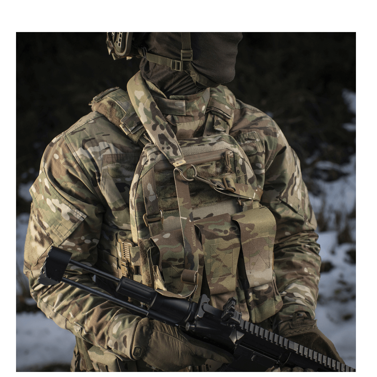 Soldat iført camouflagetøj med gevær og M-Tac Universal Våbenrem, klar til handling i udendørs omgivelser.