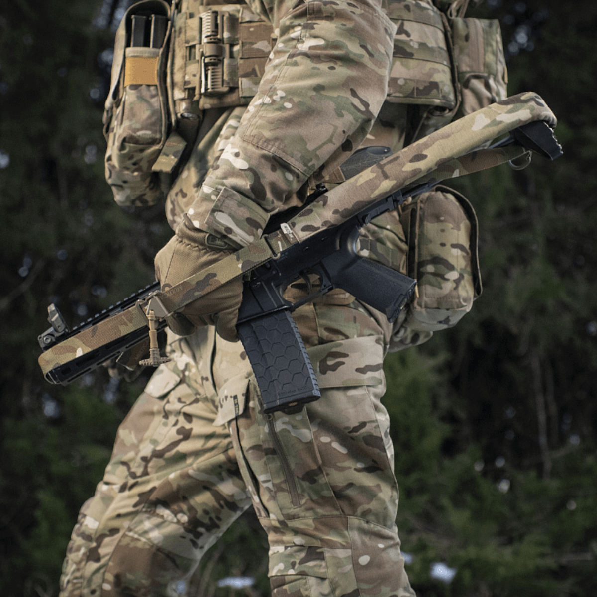 Soldat iført M-Tac Universal Våbenrem i kamouflageudstyr med gevær.