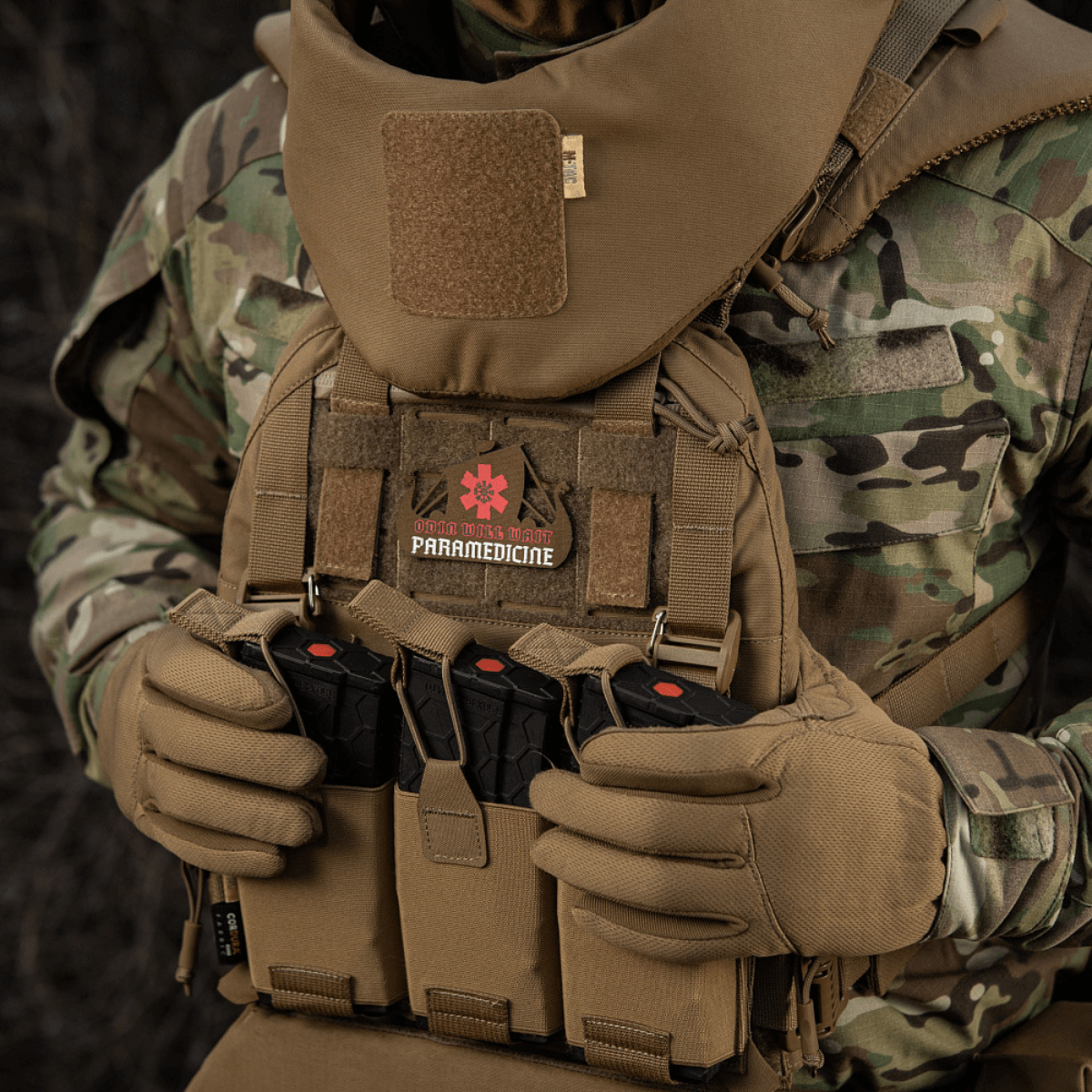 Tactical gear with M-Tac Patch Viking Evac design displayed on camouflage uniform.