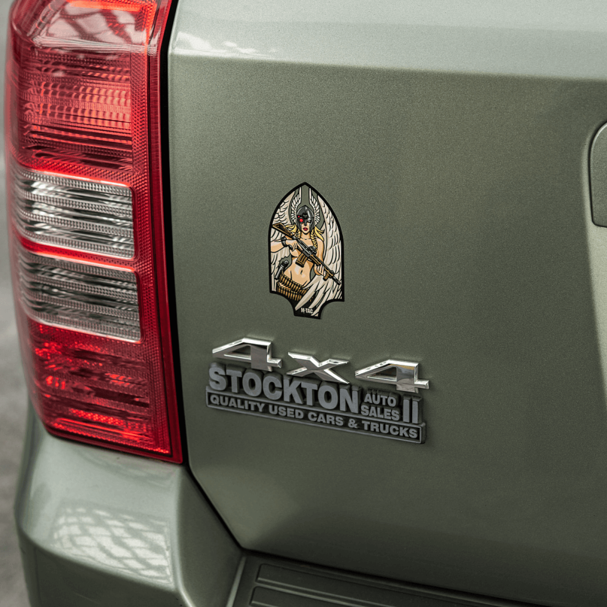 M-Tac Sticker Valkyrie monteret på bilbagklap, viser mytologisk krigsgudinde med M4 gevær i Arrowhead patch stil.