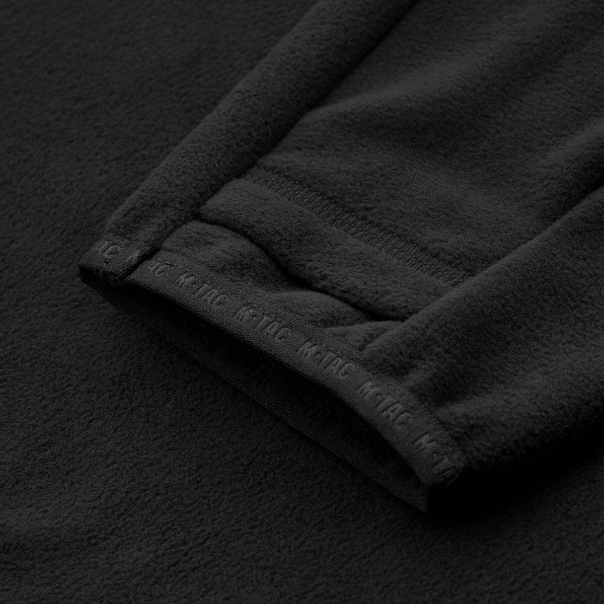 Detalje af M-Tac Delta Fleece Jakke med tommelfingerhuller. Ideel til udendørs aktiviteter i koldt vejr. Materiale: fleece 190 g/m².