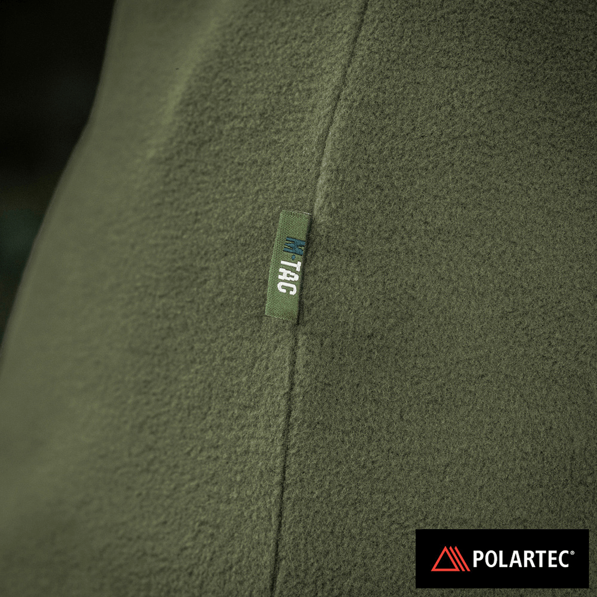 Nærbillede af M-Tac Delta Polartec Fleecejakke Dame i grøn med Polartec® logo, fremstillet af Polartec® Micro Series-fleece.