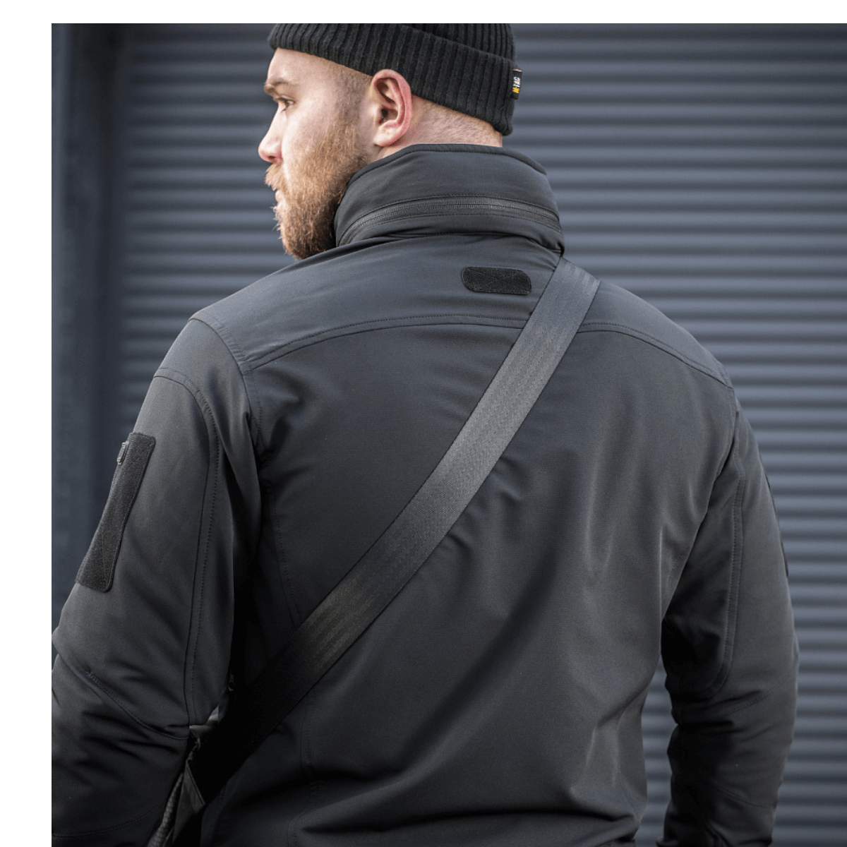 Mand iført M-Tac Konvert Taske Elite i sort, set bagfra med justerbar skulderrem, på en grå baggrund.