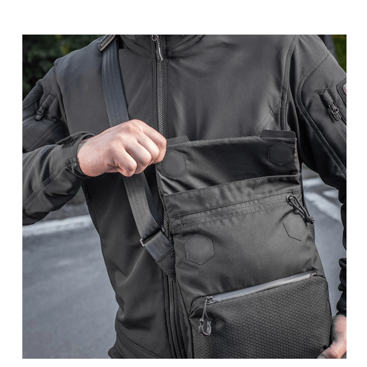 Mand bærer M-Tac Konvert Taske Elite i Cordura materiale, justerbar skulderrem og magnetlås. Ideel til alsidigt brug og hurtig adgang.