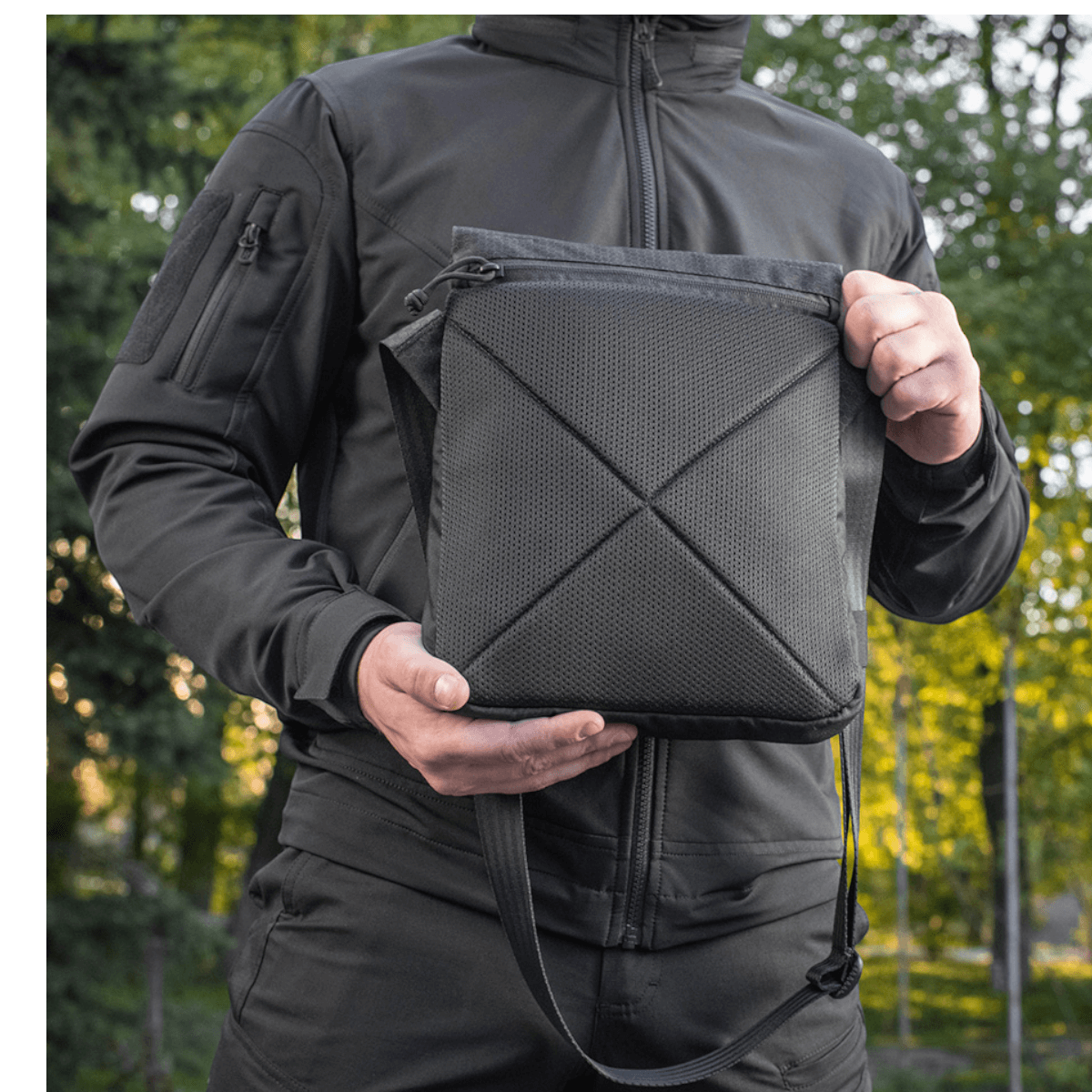Person holder M-Tac Konvert Taske Elite lavet af robust Cordura, designet til alsidighed og komfort med magnetlukning og justerbar rem.
