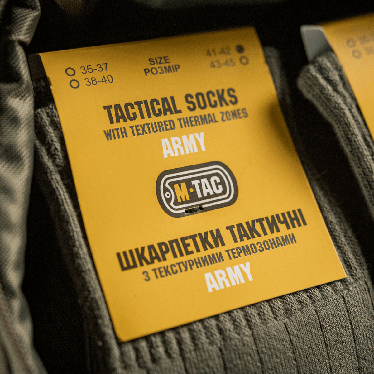 M-Tac Sokker Tactical Army etikette med størrelse og produktinformation på gult kort med teksturerede termiske zoner.