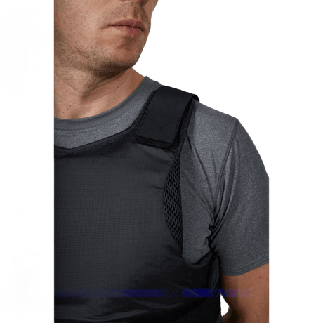 Anorak Rhodium® Concealable II stikk- og skuddsikker vest båret av mann i grå genser, viser diskret og sterk beskyttelse nivå Level IIIA.