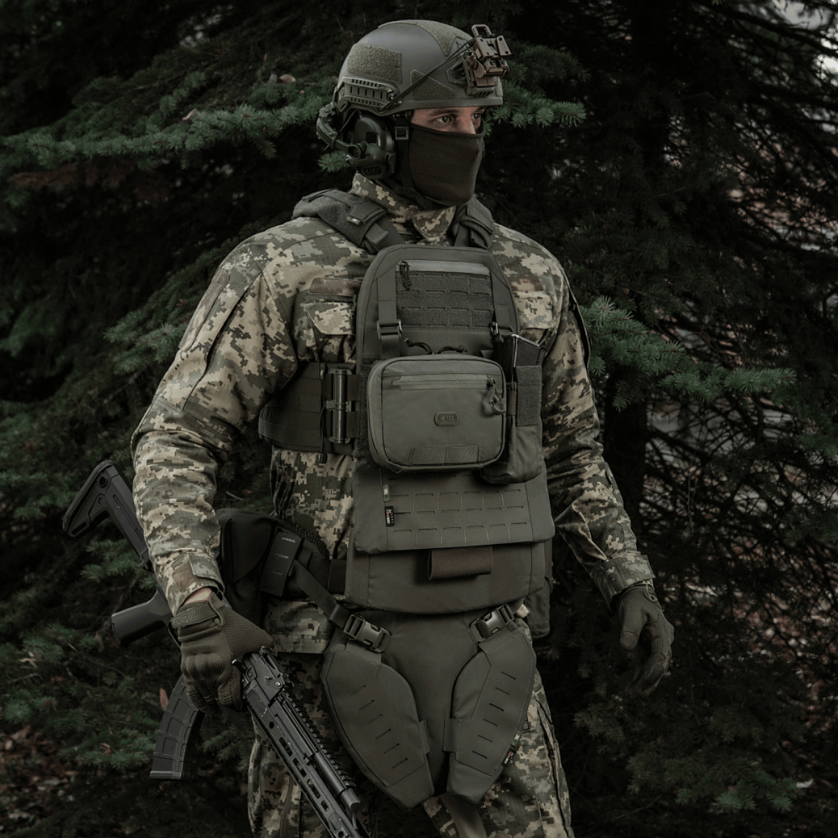 Soldat iklædt kamuflageudstyr med M-Tac organizer pouch Elite i skovmiljø.