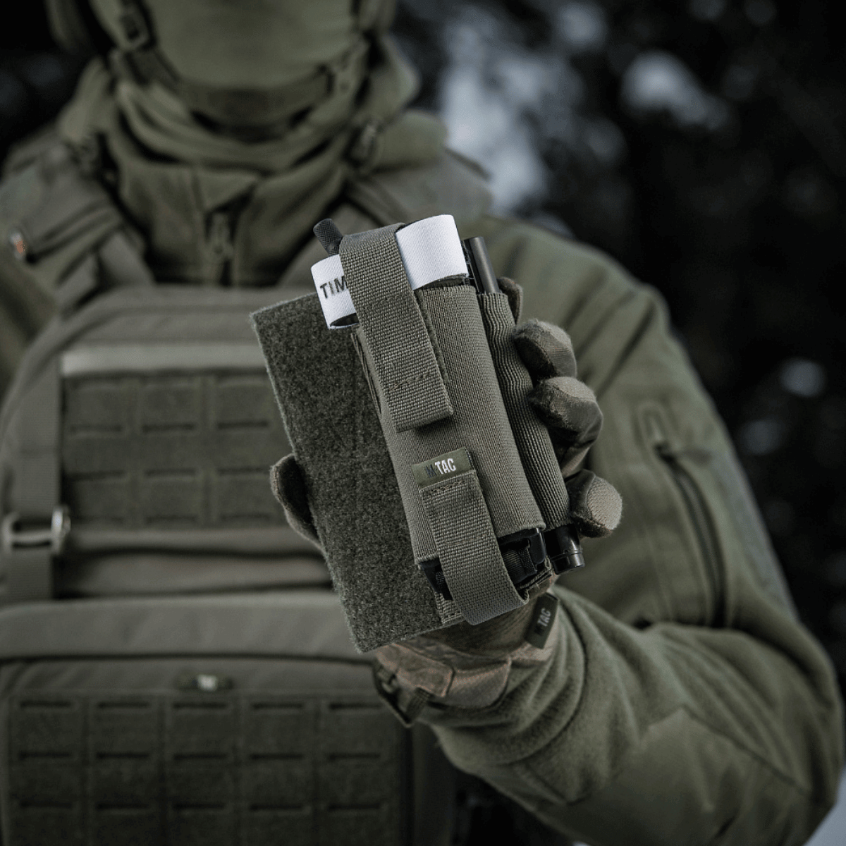 M-Tac Elastisk Tourniquet Holder Gen. III i brug af en taktisk soldat i felten, robust og slidstærk design