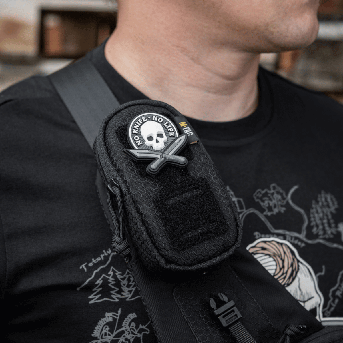 Mand bærer M-Tac PC Utility Taske Elite Hex Gen. II monteret på skulderstrop, lavet af holdbart Cordura materiale.