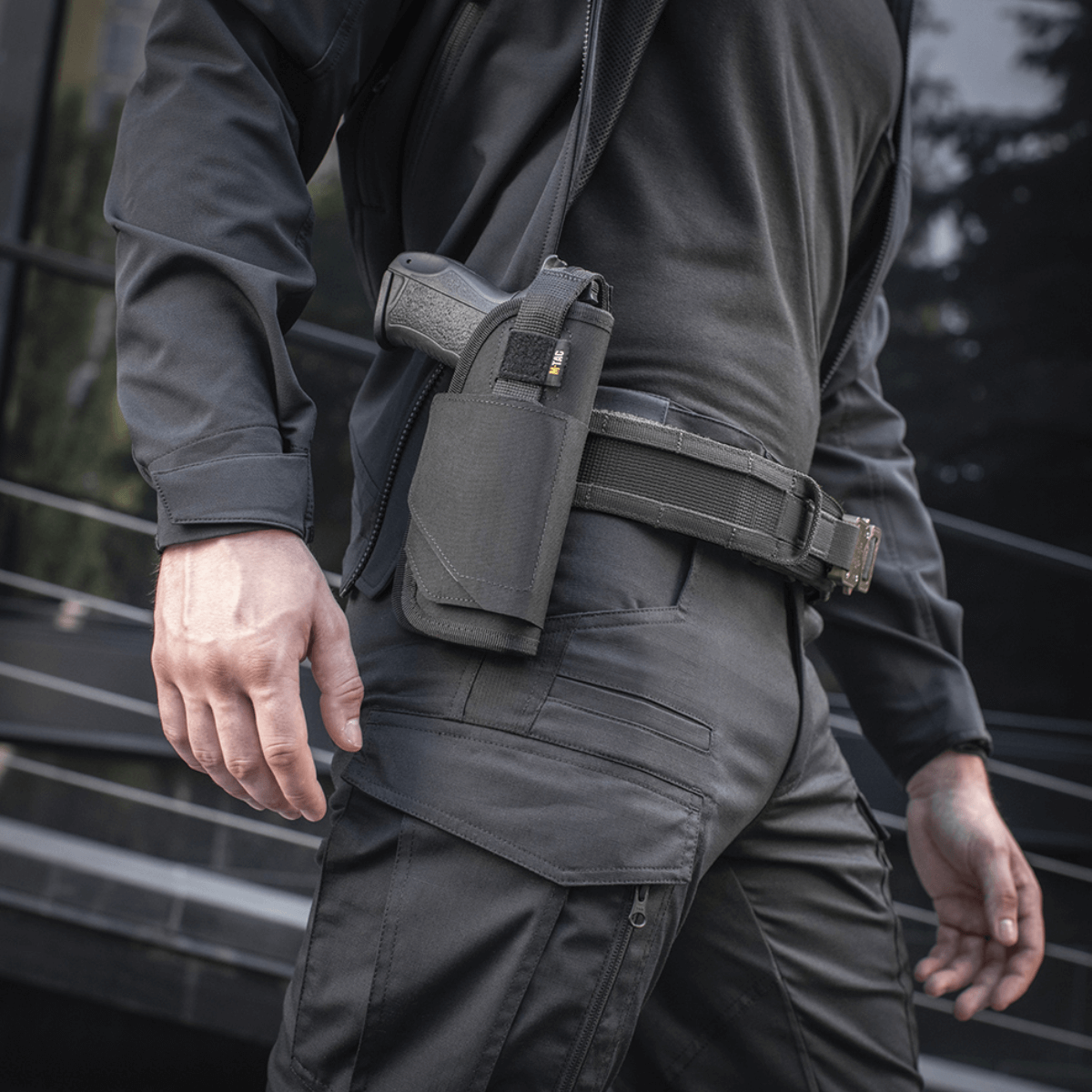Mand iført M-Tac Universal Taktisk Hylster Elite Højre i sort, justerbar holster på bælte, ideel til Glock 17, med YKK strop.
