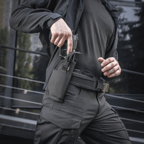Person iført M-Tac Universal taktisk hylster Elite høyre, trekker en pistol fra et justerbart hylster med Laser Cut-teknologi.