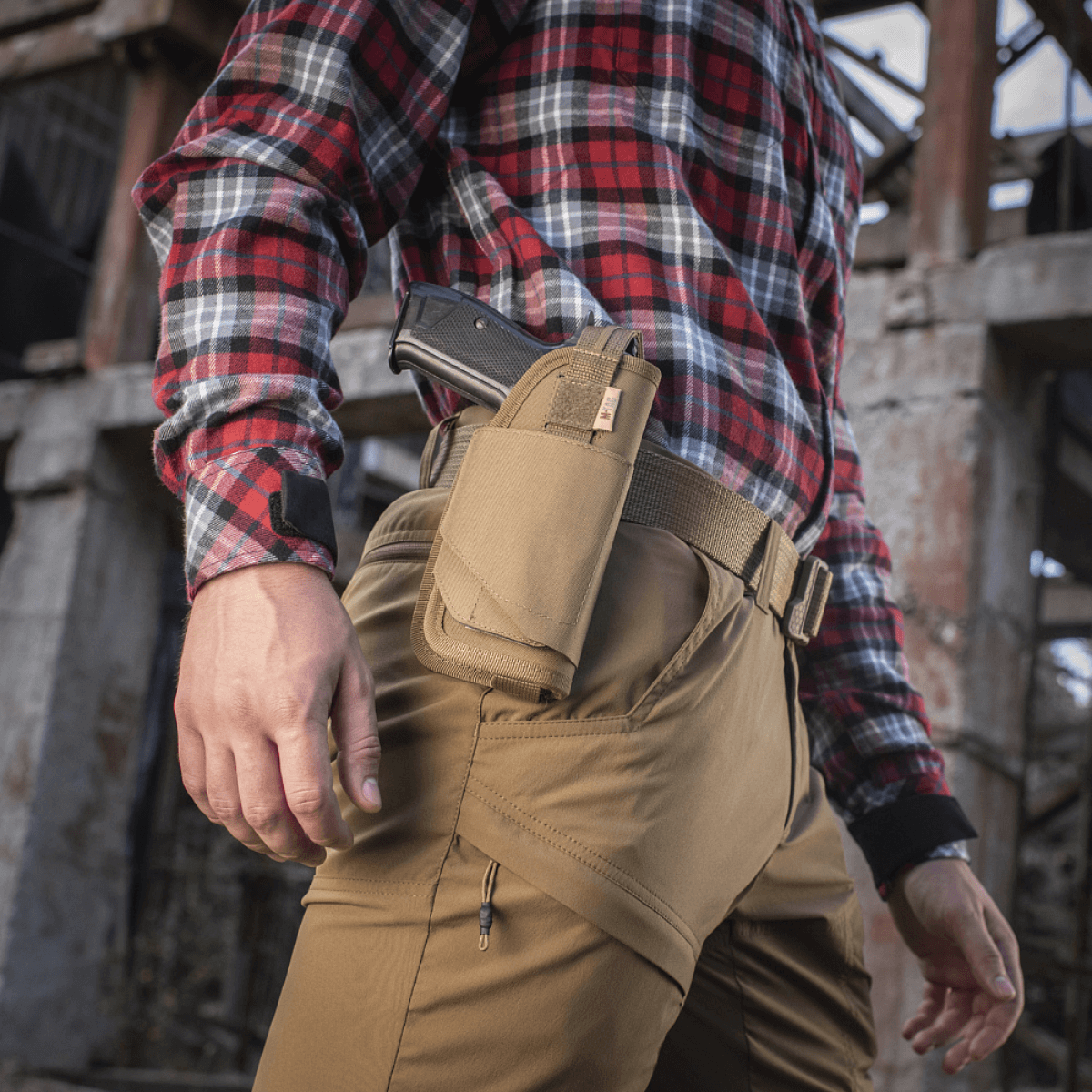 M-Tac Universal Taktisk Hylster Elite Højre fastgjort til mand i friluftsmiljø, viser holsters pasform og holdbarhed.