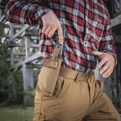 M-Tac Universal taktisk hylster Elite høyre med justerbar stropp og MOLLE-interface for belte, vist utendørs med pistol.