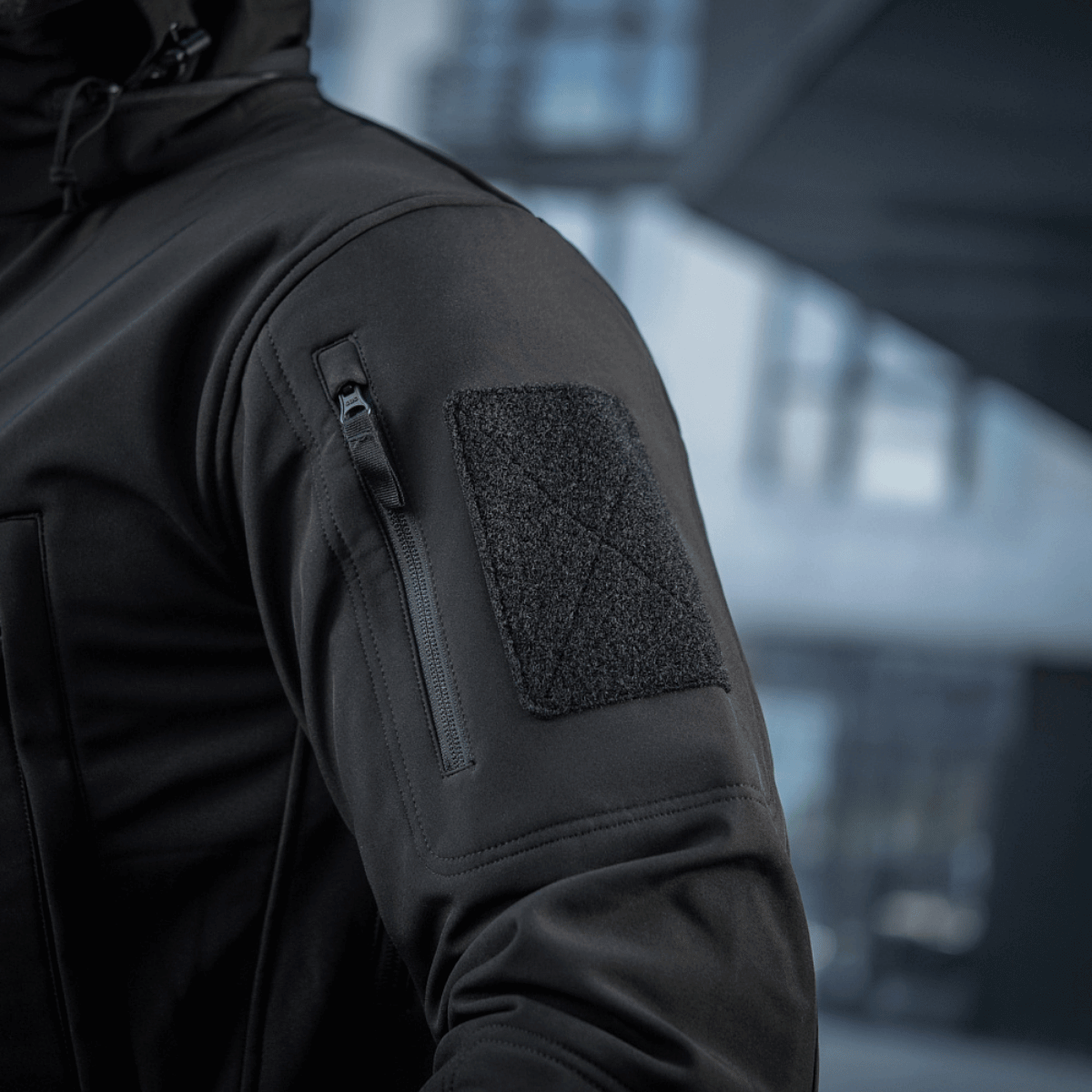 M-Tac Soft Shell Jakke i sort med velcrolomme og lynlås, ideel til beskyttelse mod dårligt vejr og isolering, let af vægt.