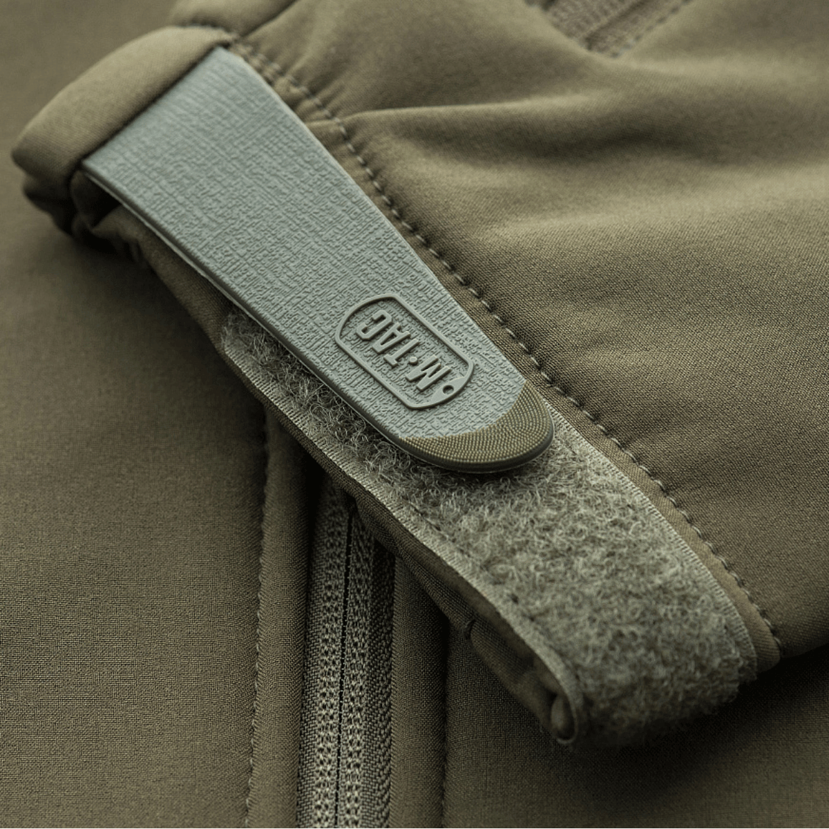 Detalje af M-Tac Soft Shell Police Jakke med robust velcrolukning og M-Tac branding, perfekt til politibrug i vind og vejr.