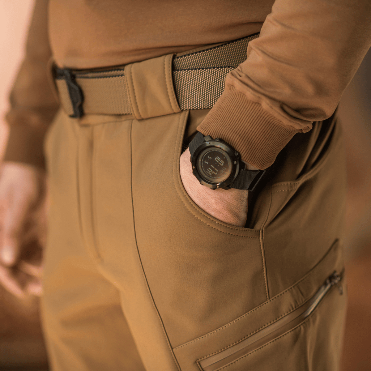 Mand iført M-Tac Bukser Soft Shell Vinter med fleecefor og høj talje, ideelle til kolde årstider, viser komfort under brug.