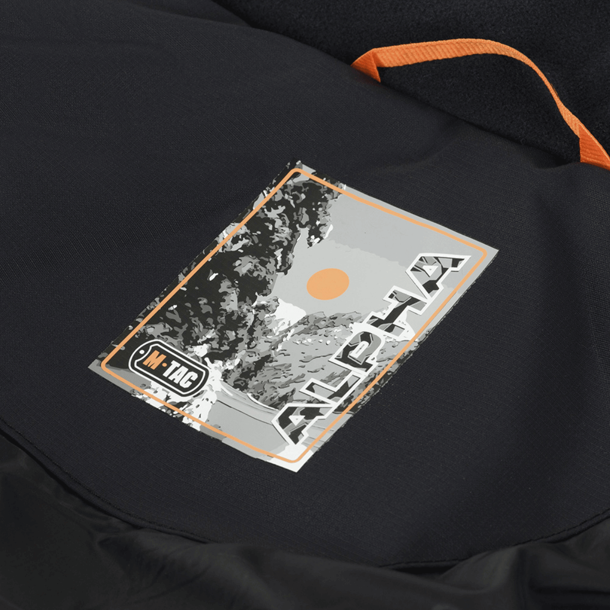 Nærbillede af M-Tac Alpha Gen.III Pro Vinterjakke med mærkat der viser vinterlandskab og sol, fremstillet af vandafvisende nylon.