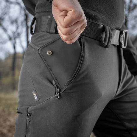 M-Tac Bukser Soft Shell Vent viser detaljer af lommen og beskyttende design, ideel til skiftende vejrforhold med vind- og fugtmodstand.