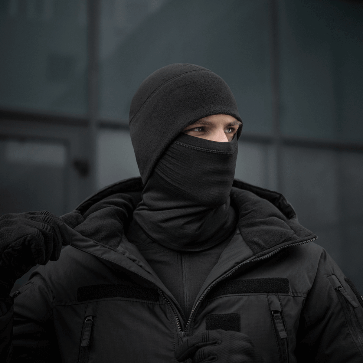 alt="Person iført M-Tac Tube Scarf Polartec Power Grid halsrør i sort, der beskytter mod vind og kulde"