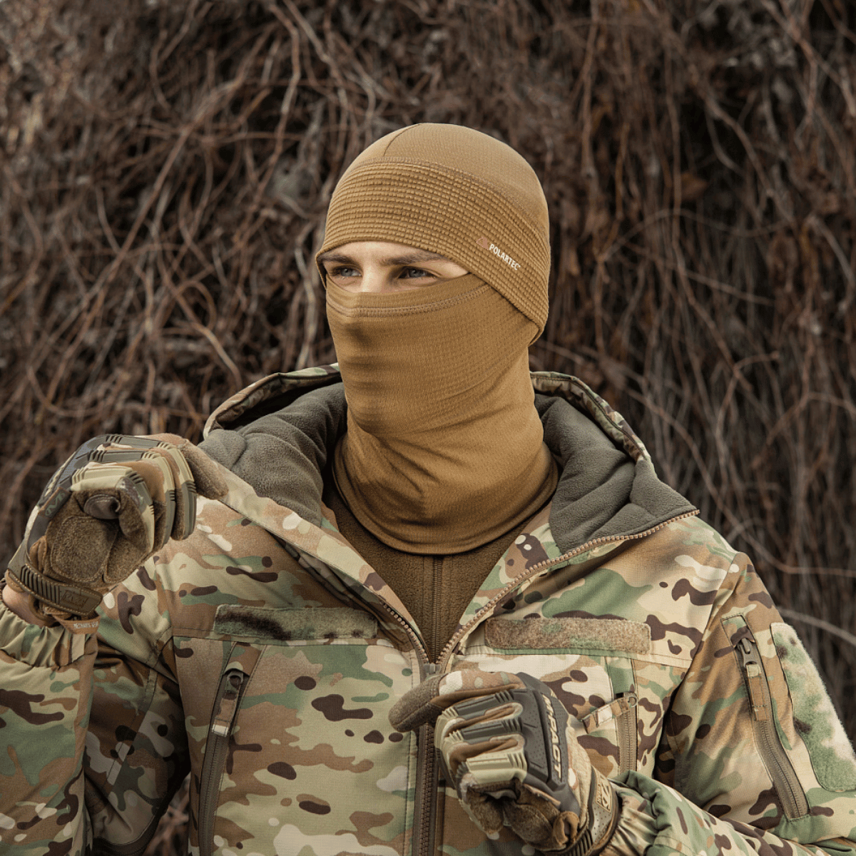 Person iført M-Tac Tube Scarf Polartec Power Grid i skovmiljø, beskytter ansigt og hals mod kulde og vind.