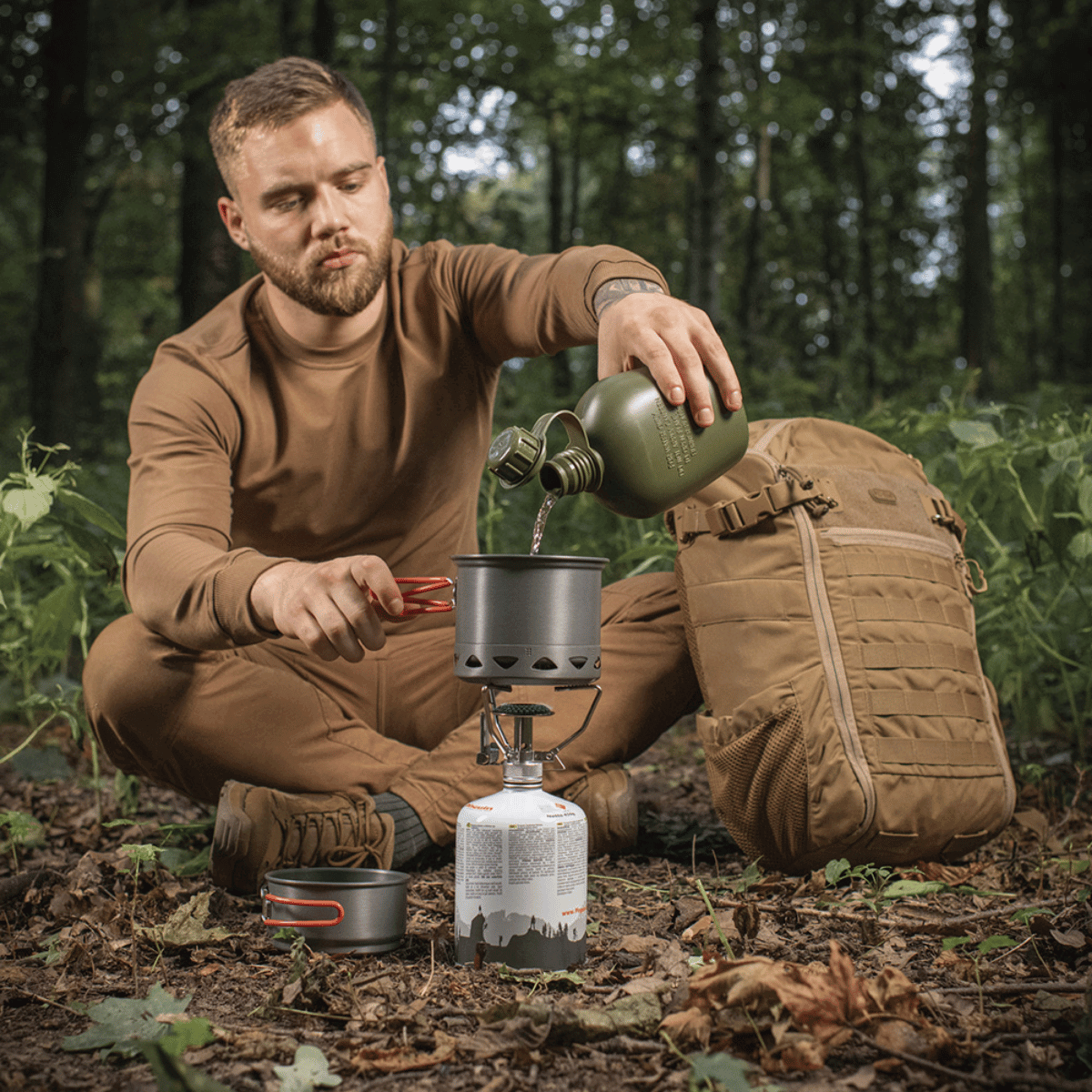 Mand bruger M-Tac Individuelt Kogesæt til Brænder under udendørs camping i skov