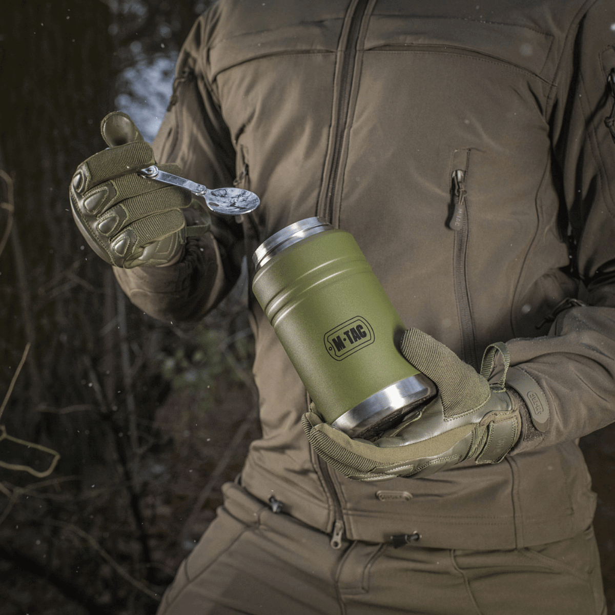 Person holder M-Tac Termoflaske 750 ml med Folde-ske i grønt design, ideel til camping og vandring.