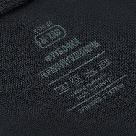 M-Tac Sweat-Wicking T-Shirt Gen.II etikette med vaskeinstruktioner og stofsammensætning i 100% polyester, set tæt på.