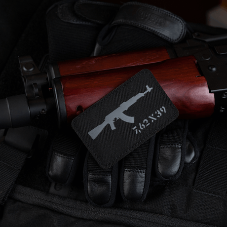 M-Tac AKM 7,62x39 Laser Cut-patch med Velcro festet på rifle, slitesterkt Cordura 500D-design, perfekt for militær- og friluftsbruk.