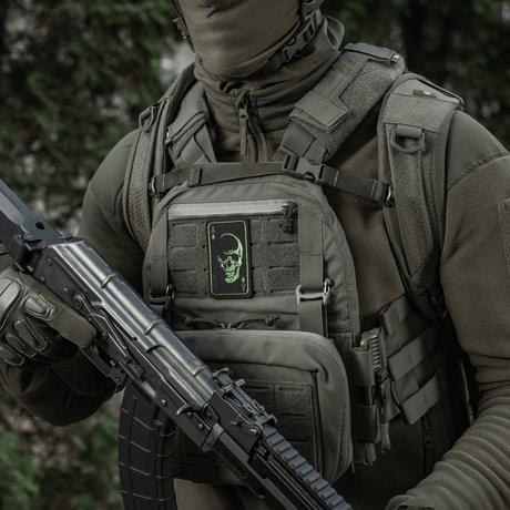Person med M-Tac Patch Face of War (broderi) på vest, brodert kranium, inspirert av Vietnamkort, festet med Velcro, taktisk utstyr.