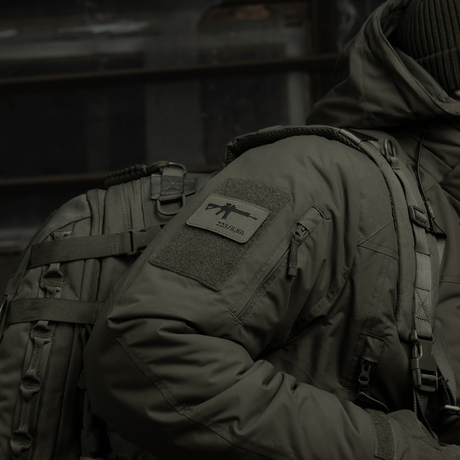 Taktisk jakke med M-Tac AR-15 223/5,56 Laser Cut-patch, festet med Velcro på skulderen, militær stil.