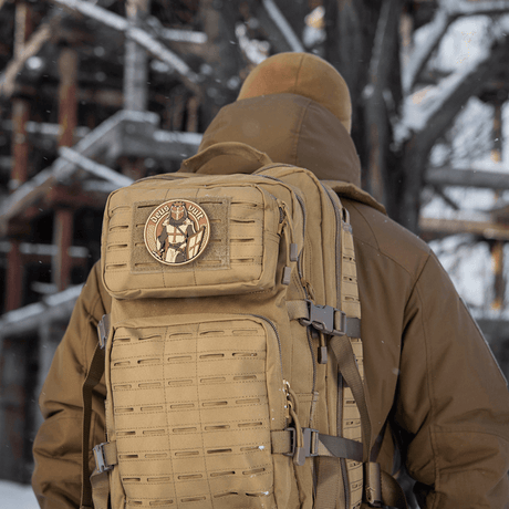 M-Tac Deus Vult 3D PVC-patch montert på en taktisk ryggsekk i vinterlandskap.