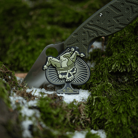 M-Tac Ace of Spades 3D PVC Patch med velcro på mose i naturen. Taktisk morale-patch for militær, airsoft og friluft.
