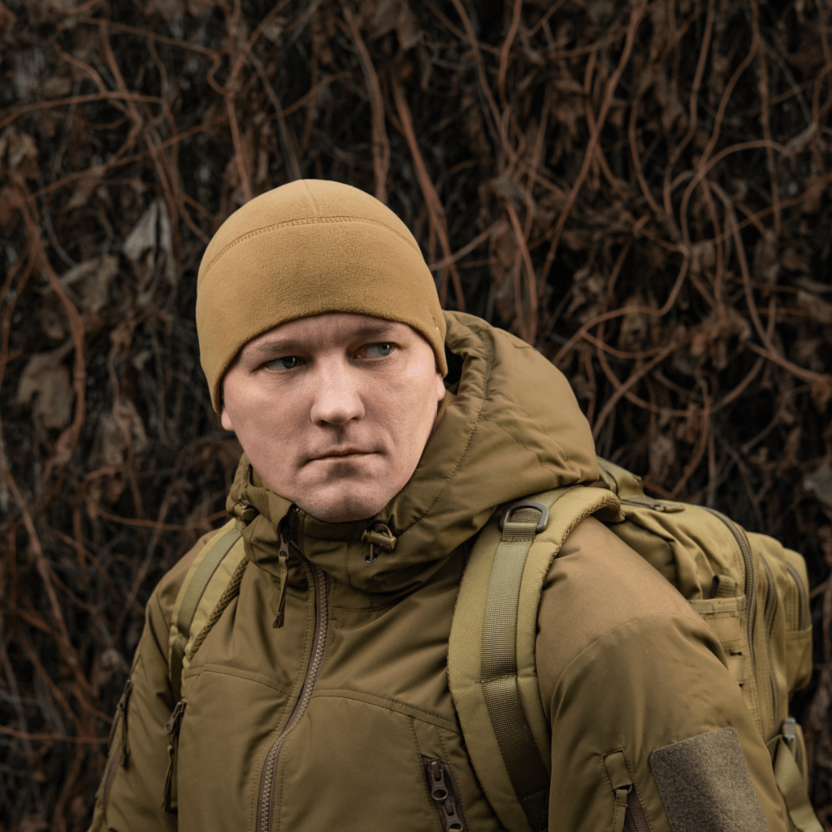 Mand iført M-Tac Fleece Watch Cap Light Polartec vinterhue i naturen, med rygsæk. Passer til vinterbrug, lavet af Polartec Micro Series fleece.